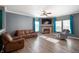 Comfortable living room features hardwood floors, a fireplace, and bright windows with blue curtains at 1257 Rosemary Ct, Greenfield, IN 46140