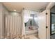 Bright bathroom showcasing a tub with curtain detail, neutral walls, and an open doorway at 1274 Old Heritage Pl, Greenwood, IN 46143