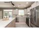 Bright kitchen features stainless steel appliances, white cabinets, quartz countertops, and stylish tile backsplash at 1274 Old Heritage Pl, Greenwood, IN 46143