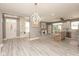 Open-concept living space featuring a modern chandelier, built-in bookshelves, and a view into the bright kitchen at 1274 Old Heritage Pl, Greenwood, IN 46143