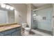 Bright bathroom featuring granite vanity and a glass shower with a tiled accent wall at 12833 Tradd St # 1B, Carmel, IN 46032
