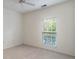 A basic bedroom with a neutral carpet, a standard window and ceiling fan at 12833 Tradd St # 1B, Carmel, IN 46032