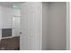 A view inside an empty closet with white walls and a door ajar, offering ample storage space at 12833 Tradd St # 1B, Carmel, IN 46032