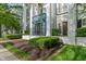 The building's entry has attractive landscaping and a charming covered entrance with black doors at 12833 Tradd St # 1B, Carmel, IN 46032