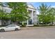 Charming condo building with mature trees, manicured bushes, and white car in the foreground at 12833 Tradd St # 1B, Carmel, IN 46032