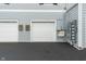 Two-car garages in a neutral color with asphalt driveway and electrical boxes on the building exterior at 12833 Tradd St # 1B, Carmel, IN 46032