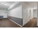 Well-lit hallway with multiple doors, exit sign, and safety equipment at 12833 Tradd St # 1B, Carmel, IN 46032