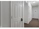 A clean, well-maintained hallway featuring multiple white doors along a carpeted floor at 12833 Tradd St # 1B, Carmel, IN 46032