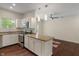 Well-lit kitchen features stainless appliances, white cabinets, granite counters, and an island at 12833 Tradd St # 1B, Carmel, IN 46032