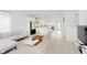 Open-concept living room with a modern kitchen and light wood-style flooring at 12990 Moultrie St, Carmel, IN 46032