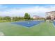 Community tennis court surrounded by trees and residential buildings with a pond view at 12990 Moultrie St, Carmel, IN 46032