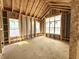 Bright bedroom under construction featuring wood framing, three windows, and natural light throughout the unfinished space at 1415 Beaumont Cir, Westfield, IN 46074