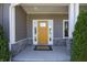 Inviting front porch with a vibrant yellow door and classic stone pillar accents at 1472 Maple Ridge Ct, Columbus, IN 47201