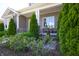 Close-up of a welcoming porch featuring stone pillars, comfortable seating, and lush greenery at 1472 Maple Ridge Ct, Columbus, IN 47201