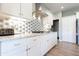 Detailed view of a kitchen with white cabinets, granite countertops, and modern appliances at 1472 Maple Ridge Ct, Columbus, IN 47201