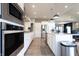 Well-lit kitchen showcasing an island, stainless steel appliances, and wood-look flooring at 1472 Maple Ridge Ct, Columbus, IN 47201