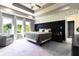 Bright bedroom featuring a stylish bed, decorative wall accents, and a cozy sitting area by the large windows at 1472 Maple Ridge Ct, Columbus, IN 47201
