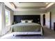 Bright bedroom featuring a stylish bed, decorative wall accents, and a cozy sitting area by the large windows at 1472 Maple Ridge Ct, Columbus, IN 47201