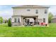 Spacious backyard featuring a covered patio with seating, grill, and hot tub at 15143 Gallop Ln, Fishers, IN 46040