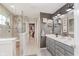 Well-lit bathroom features double vanity, framed mirrors, and glass-enclosed shower and a walk-in closet at 15143 Gallop Ln, Fishers, IN 46040