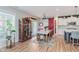 Open-concept dining room with wood floors, sliding barn door, wine cabinet, and backyard access at 15143 Gallop Ln, Fishers, IN 46040