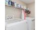 Well-lit laundry room featuring a washer, dryer, shelving, and laundry supplies at 15143 Gallop Ln, Fishers, IN 46040