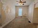 Empty bedroom with peeling wallpaper and a ceiling fan needing repairs at 152 1St W St, Shelbyville, IN 46176
