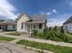 Street view of a cozy one-story home with vinyl siding, a quaint porch, and lush landscaping under a bright sky at 152 1St W St, Shelbyville, IN 46176
