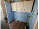 Laundry room with blue walls and white cabinets at 152 1St W St, Shelbyville, IN 46176