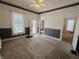 Bright living room with doorways into other rooms, carpeted floor, and ceiling fan, offering versatility for modern living at 152 1St W St, Shelbyville, IN 46176