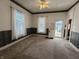 Bright living room with carpeted floor, ceiling fan, and natural light streaming through the windows creating an inviting space at 152 1St W St, Shelbyville, IN 46176