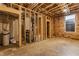 Unfinished basement featuring exposed framing, utilities, a small window, and concrete floor for future customization at 1520 Central Ave, Indianapolis, IN 46202