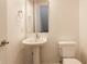 This bathroom features a modern pedestal sink, a large mirror, and a toilet with white walls at 1520 Central Ave, Indianapolis, IN 46202