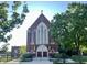 Beautiful exterior view of a brick building with a cross on top, framed by lush green trees at 1520 Central Ave, Indianapolis, IN 46202