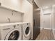 A modern laundry room features appliances, overhead shelving, and wood-look flooring at 1520 Central Ave, Indianapolis, IN 46202