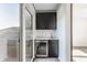 Stylish wet bar on porch with dark cabinets, white countertop, stainless steel beverage cooler, and sliding glass door at 1520 Central Ave, Indianapolis, IN 46202