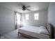 Neutral carpeted bedroom with a ceiling fan and natural light from two windows with curtains at 15413 Staffordshire Way, Fishers, IN 46037