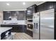 Modern kitchen boasts stainless steel appliances, dark cabinetry, and a stylish tile backsplash at 15413 Staffordshire Way, Fishers, IN 46037