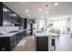 Open kitchen with stainless steel appliances, dark cabinets, and modern lighting at 15413 Staffordshire Way, Fishers, IN 46037