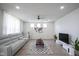 Comfortable living room with a plush sofa, ceiling fan, and a decorative accent wall at 15413 Staffordshire Way, Fishers, IN 46037