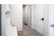 Hallway with mudroom bench and hooks leads to room with gray floor tiles and robot vacuum at 15413 Staffordshire Way, Fishers, IN 46037