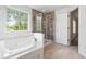 Bathroom showcasing tub, glass shower, and window with natural light at 16001 Concert Way, Noblesville, IN 46060