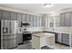 Modern kitchen with stainless steel appliances, gray cabinets, and a central island for food preparation at 16001 Concert Way, Noblesville, IN 46060