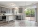 Bright and airy kitchen featuring gray cabinets, wood floors, and a sliding door to the outdoor patio at 16001 Concert Way, Noblesville, IN 46060