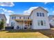 View of the back of the house with a covered patio, hot tub and a well-maintained lawn at 16516 Wilsons Farm Dr, Fishers, IN 46040
