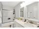 Bright bathroom featuring dual sinks, modern vanity, bathtub with a glass enclosure, and modern lighting at 16516 Wilsons Farm Dr, Fishers, IN 46040
