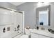 Cozy bathroom featuring a modern vanity, quartz countertop, bathtub, shower with glass enclosure, and neutral color palette at 16516 Wilsons Farm Dr, Fishers, IN 46040