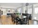 Dining area with dark wood table, seating for eight, and views into the bright, modern kitchen at 16516 Wilsons Farm Dr, Fishers, IN 46040