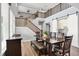 Open dining space with a dark wood table, bench, stairs, and a barn door leading to an office nook at 16516 Wilsons Farm Dr, Fishers, IN 46040