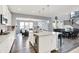 Bright, open kitchen with a large island, seating, modern lighting, and seamless flow into the living and dining areas at 16516 Wilsons Farm Dr, Fishers, IN 46040
